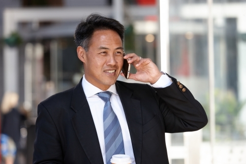 Asian businessman in city - Australian Stock Image