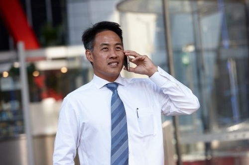 Asian businessman in city - Australian Stock Image