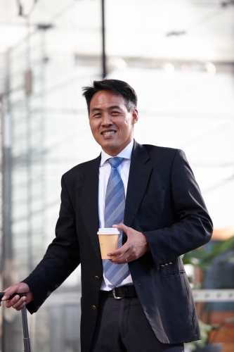 Asian businessman in city - Australian Stock Image