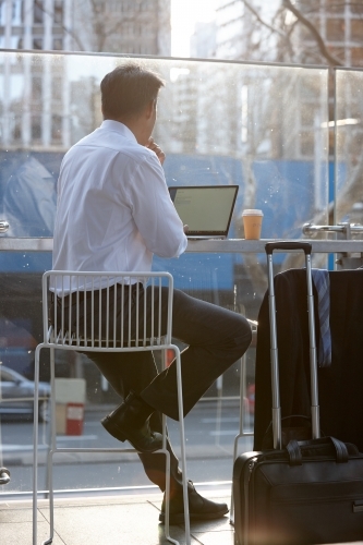 Asian businessman, working on laptop, in the city - Australian Stock Image