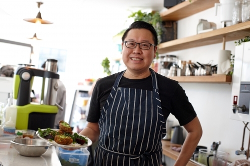 Asian chef working in kitchen at organic food cafe