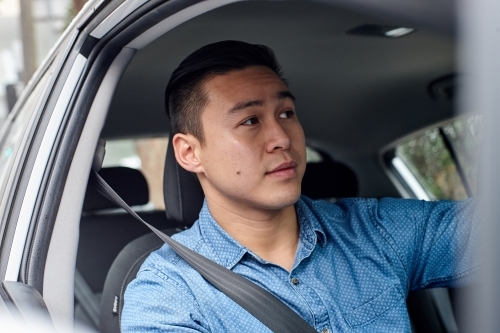 Asian man driving car - Australian Stock Image