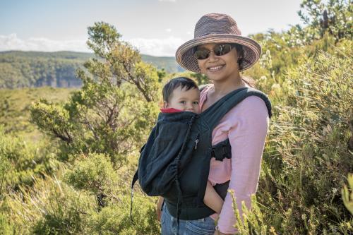 Asian mum outside walking in the summer sun with her mixed race baby boy - Australian Stock Image