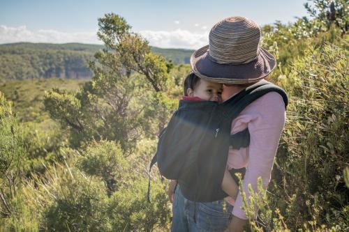 Asian mum outside walking in the summer sun with her mixed race baby boy - Australian Stock Image