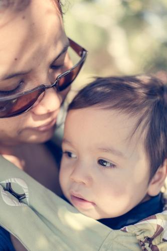 Asian mum outside walking in the summer sun with her mixed race baby boy - Australian Stock Image