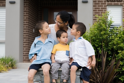 Asian mum sending her boys off to school on their first day of school - Australian Stock Image