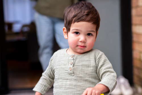 asian toddler, with mum in the background - Australian Stock Image