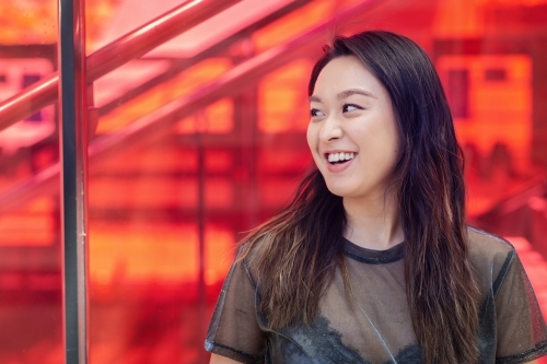 asian woman smiling at friend - Australian Stock Image