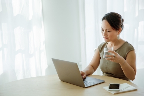 Asian woman working on a computer - Australian Stock Image