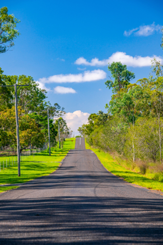 Asphalt country road with telephone poles and powerlines - Australian Stock Image