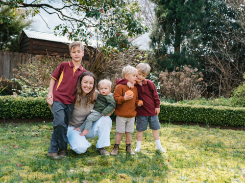 Aussie mum with her young sons gathered in the garden - Australian Stock Image