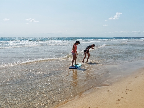 Australian coastal living boy and girl playing on the beach