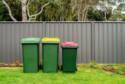 Australian home rubbish bins set provided by local council on back yard in Australian suburb - Australian Stock Image