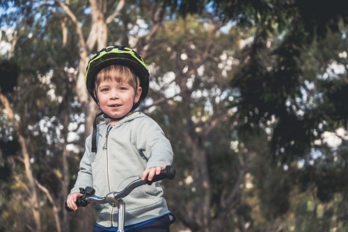 Australian kid riding his balance bike and wearing helmet in the park, South Australia - Australian Stock Image