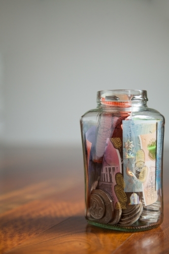 Australian money notes and coins in jar on wood with white copy space - Australian Stock Image