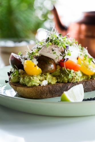 Avocado toast with chunky tomato slices. - Australian Stock Image