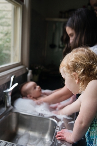 Baby bathtime in kitchen sink