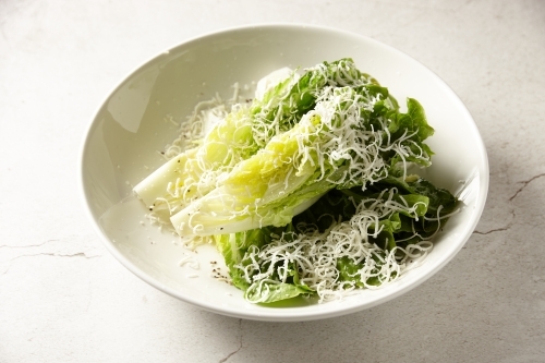 Baby cos lettuce dish on marble table - Australian Stock Image