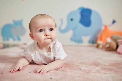 Baby girl having tummy time - Australian Stock Image