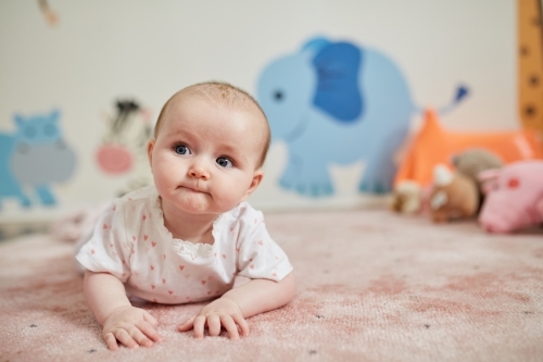 Baby girl having tummy time - Australian Stock Image