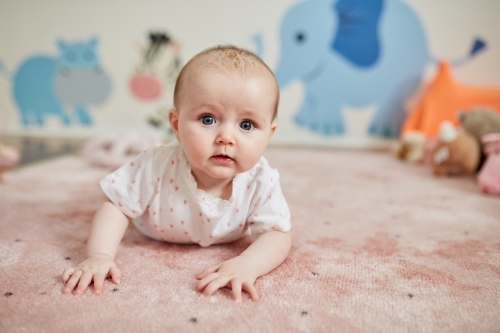 Baby girl having tummy time - Australian Stock Image