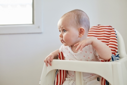 Baby girl in high chair - Australian Stock Image
