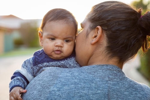 Baby looking over his mother's shoulder - Australian Stock Image