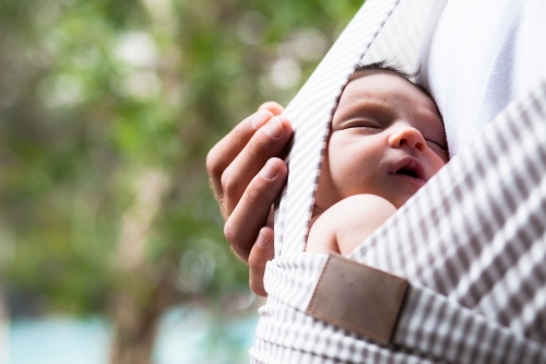 Baby sleeping in carrier - Australian Stock Image