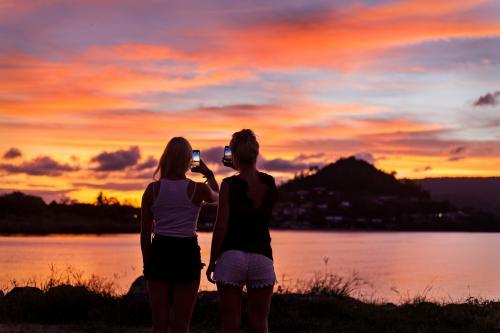 Backpackers photographing a brilliant sunset on their phones.