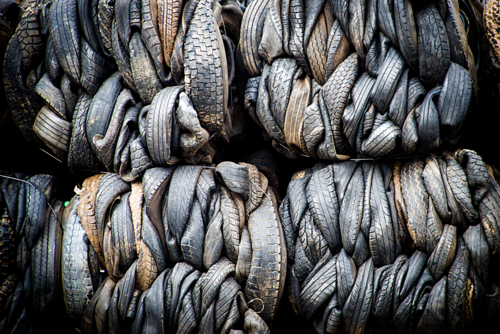 Bales of tightly compressed worn-out tyres stacked for recycling. - Australian Stock Image