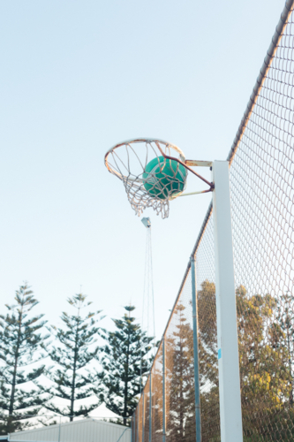 Ball going through the hoop at regional Australia netball court - Australian Stock Image
