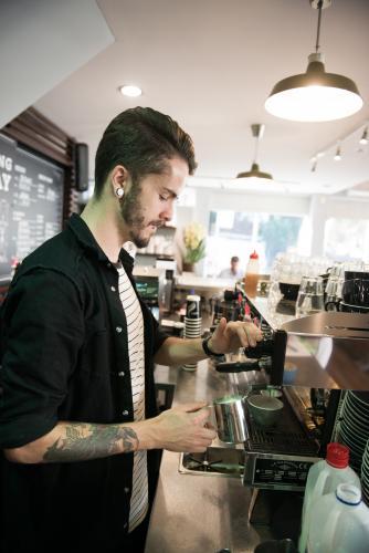 Barista making coffee inside a cafe - Australian Stock Image
