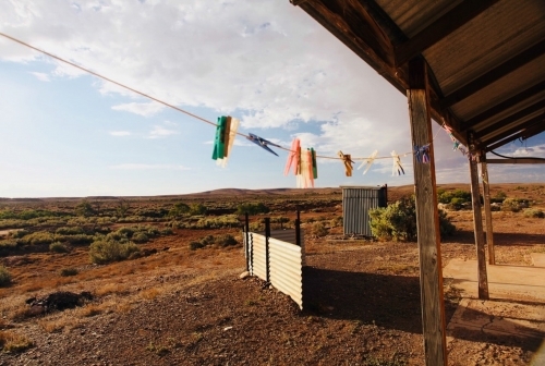 Barren landscape, pegs on line looking out from wooden dwelling - Australian Stock Image