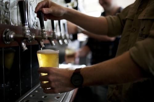 Bartenders pouring drinks from tap at local craft beer bar