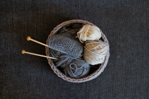 Basket of knitting, knitting needles and wool on grey background - Australian Stock Image