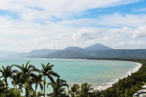 Bay with curved shoreline and palm trees - Australian Stock Image