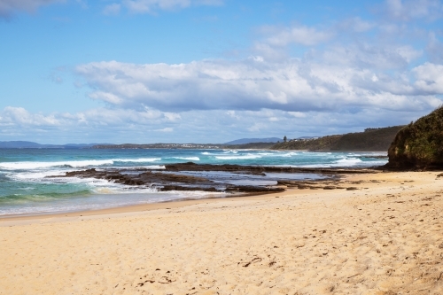 Beach cove with rocky shelf and waves - Australian Stock Image