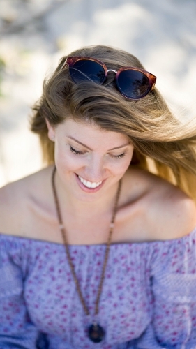 Beach girl shot from above sitting on sand - Australian Stock Image