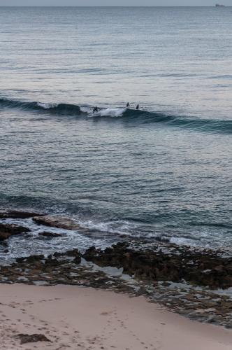 Beach landscape with surfers in distance - Australian Stock Image