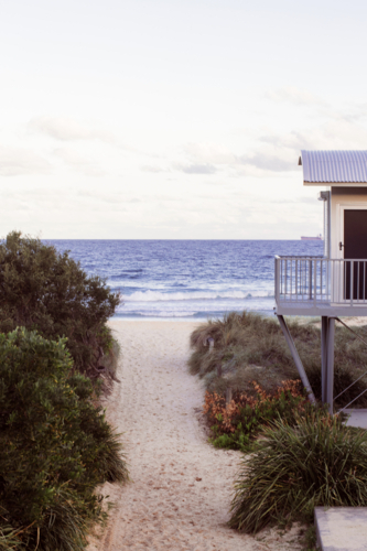 Beach observation hut standing on a sandy path that leads directly to the ocean - Australian Stock Image