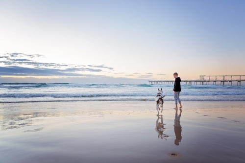 Beach reflections with boy & Dog - Australian Stock Image