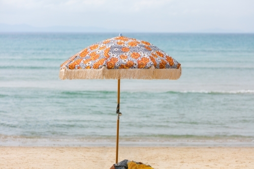 Beach umbrella on sand in front of ocean