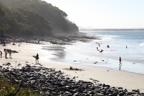 Beach with surfers and people in the distance - Australian Stock Image