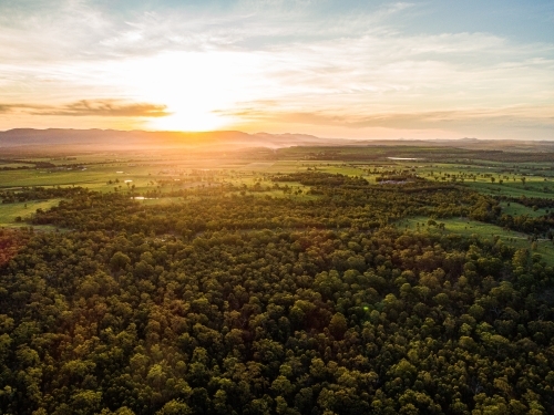 Beautiful sunset light over landscape of trees and farm land in Hunter Valley - Australian Stock Image