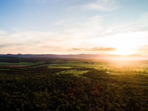 Beautiful sunset light over landscape of trees and farm land in Hunter Valley - Australian Stock Image