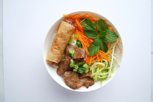 Beef noodle salad topped with fried lumpia - Australian Stock Image