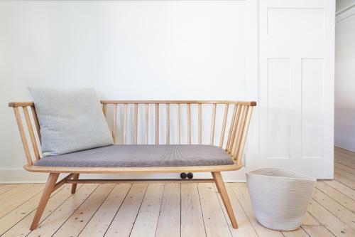 Bench seat feature chair in Danish styled white interior - Australian Stock Image
