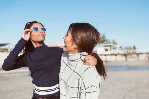 Best friends spending time on the beach laughing - Australian Stock Image