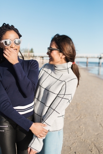 Best friends spending time on the beach laughing - Australian Stock Image