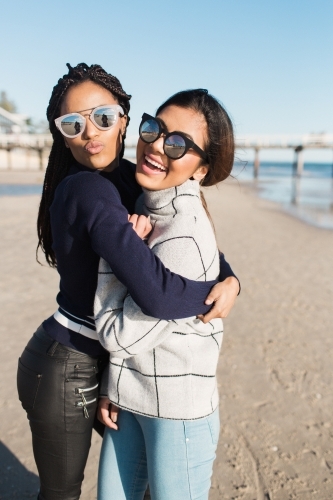 Best friends spending time on the beach laughing - Australian Stock Image